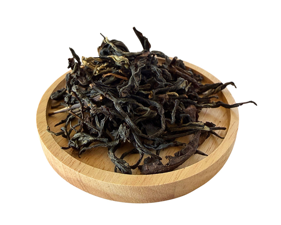 Mountain Aroma dry tea leaves on a wooden dish.