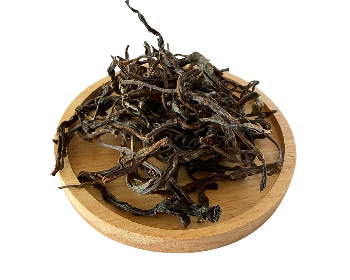Mountain Mist loose dry tea leaves on a wooden dish.