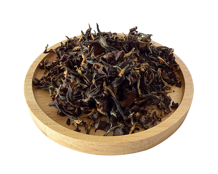 Clear Mind Tea dry leaves on a wooden dish.